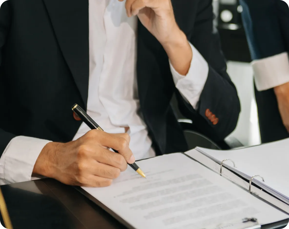 A person in suit reading a document, tracing their pen across the lines